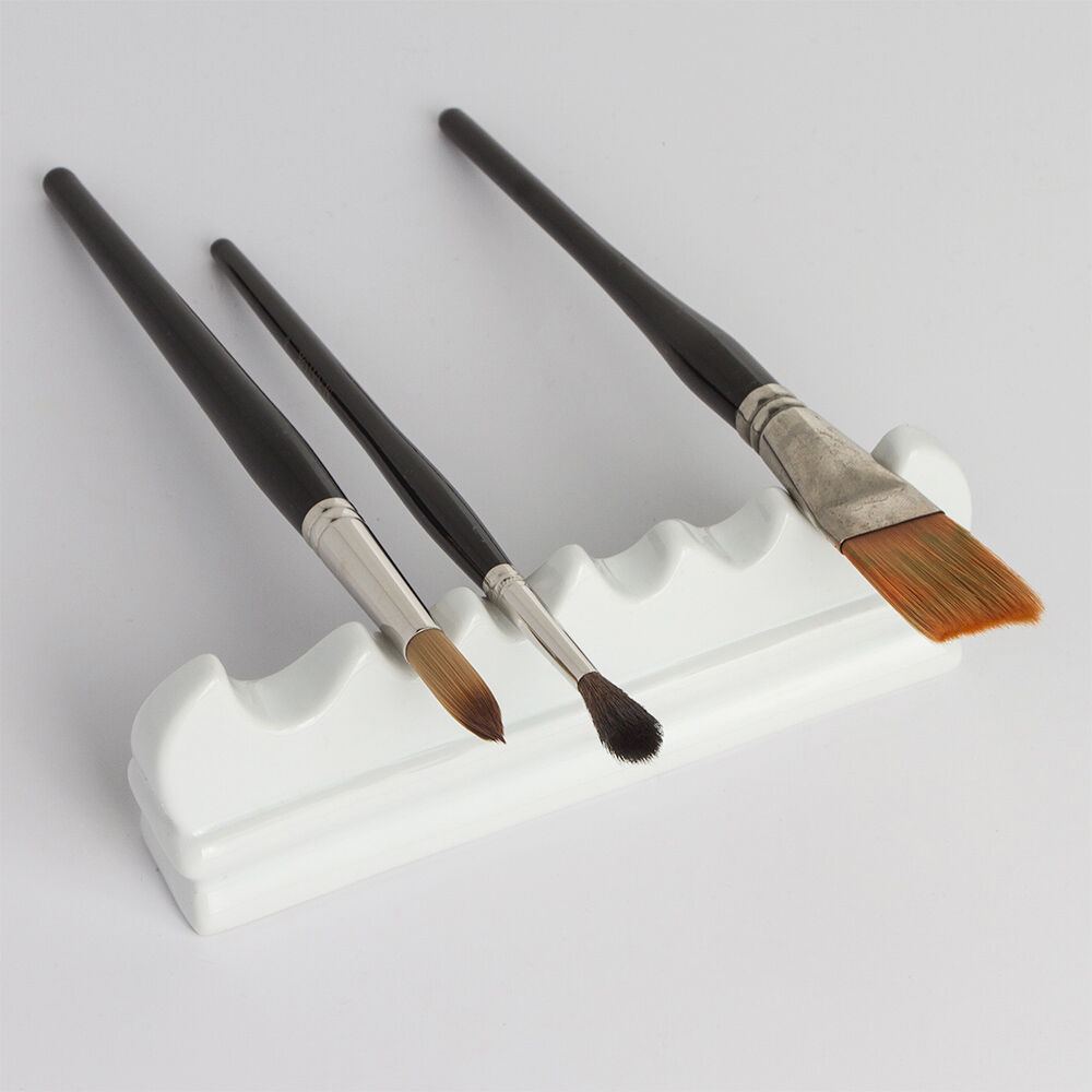 White ceramic brush rest on a white background with brushes to show how to use the brush rest.